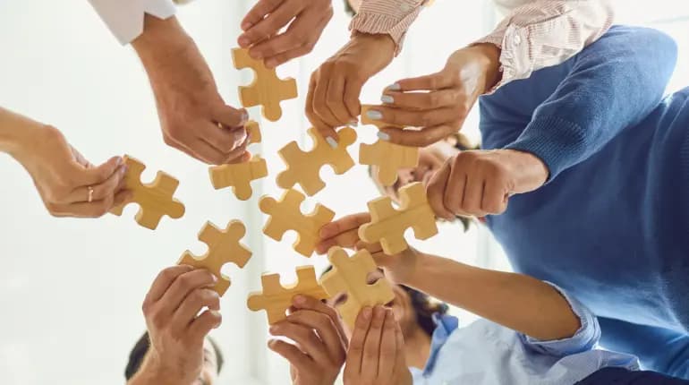 people holding large jigsaw puzzle pieces